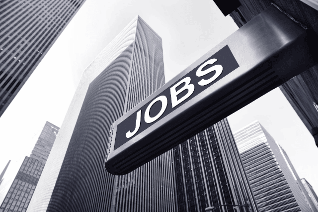 job sign in front of tall skyscraper buildings