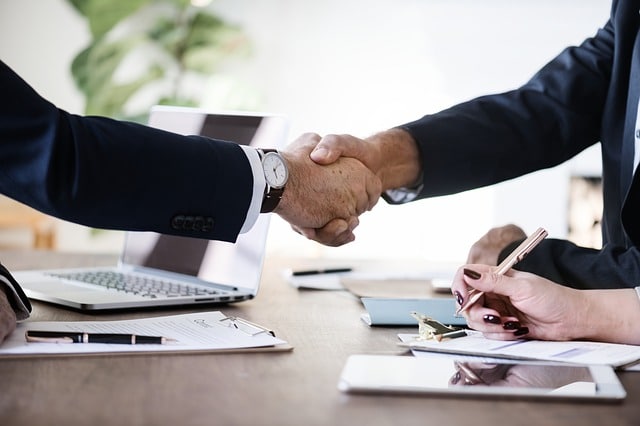 Two Roads Professional Resources image of 2 business people shaking hands in hiring agreement